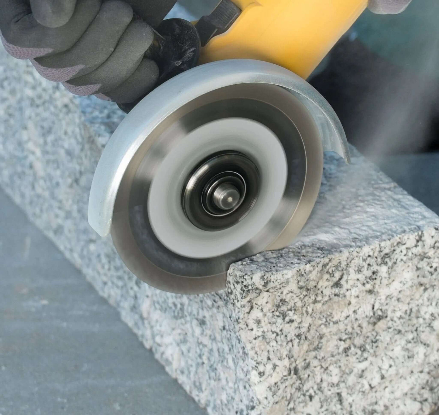 Nahaufnahme einer Diamantklinge, die durch Stein schneidet, was die Präzision und professionelle Qualität des Werkzeugs hervorhebt.